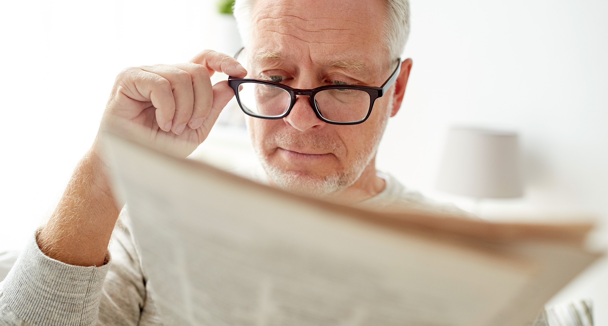 lesende Person, die eine Brille am Ende der Nase hält