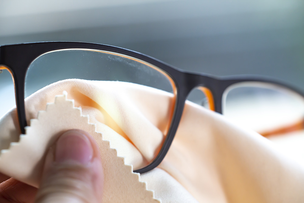 Reinigen Sie Ihre Brillengläser mit einem Antibeschlag-Mikrofasertuch.